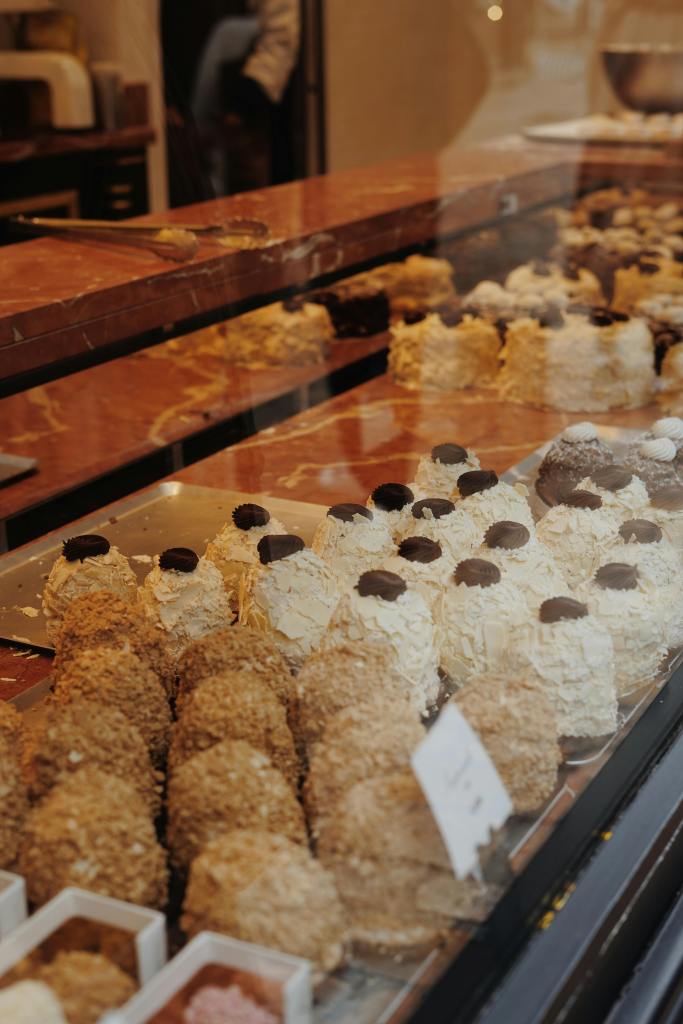 cakes of different sizes and colors in bakery window