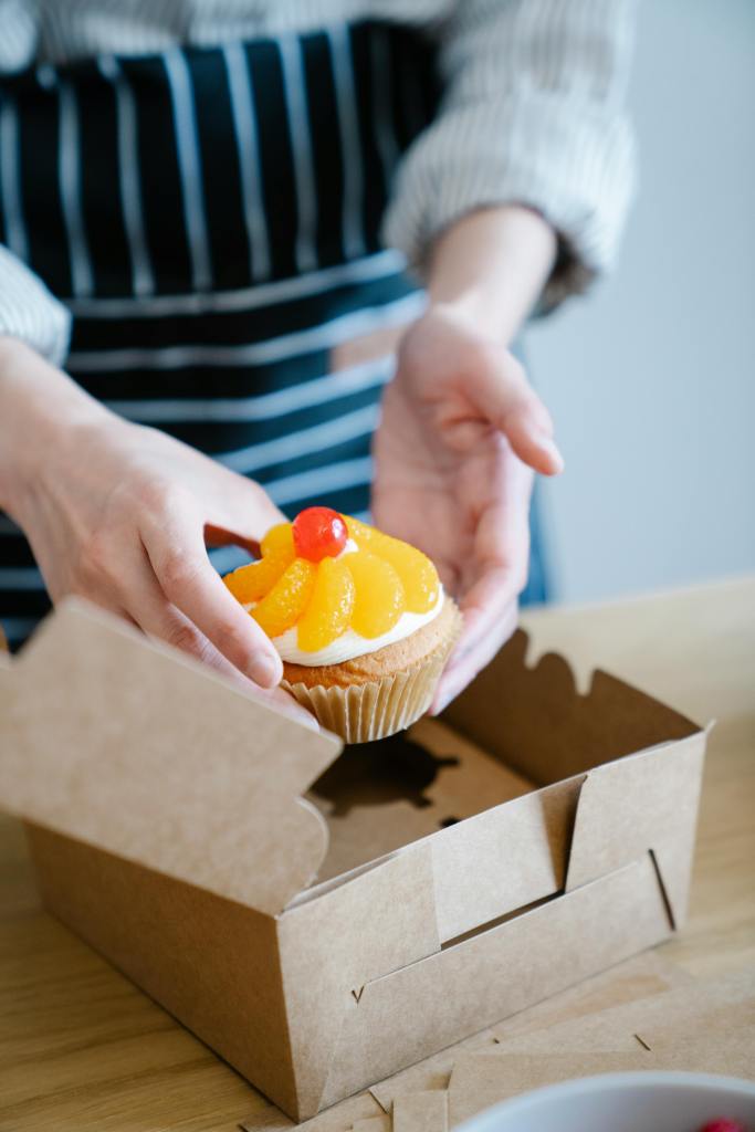 woman putting a decorated cake in a box
