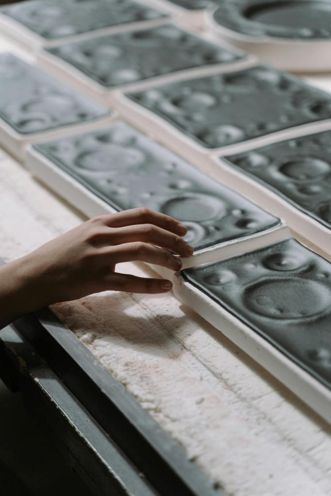 a hand touching glazed ceramics