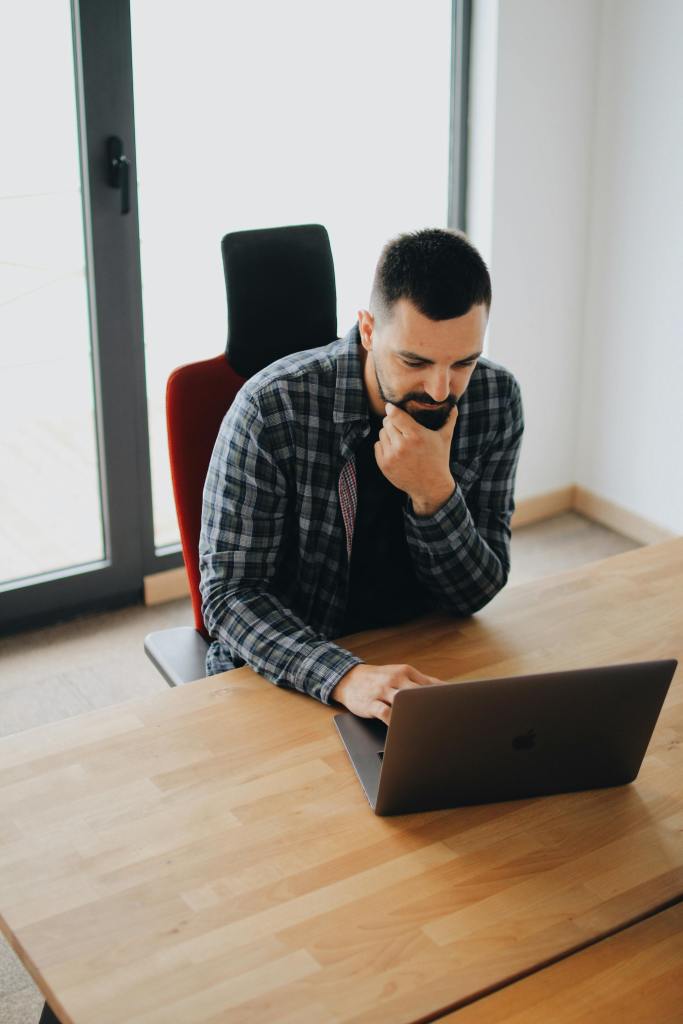 A man using a laptop on wooden table