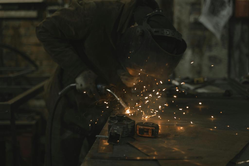 person wearing a welding helmet welding metal with sparks flying