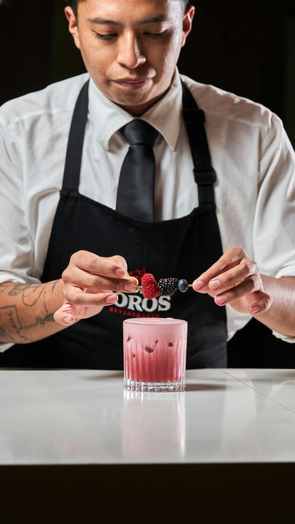 chef garnishing a smoothie with strawberries