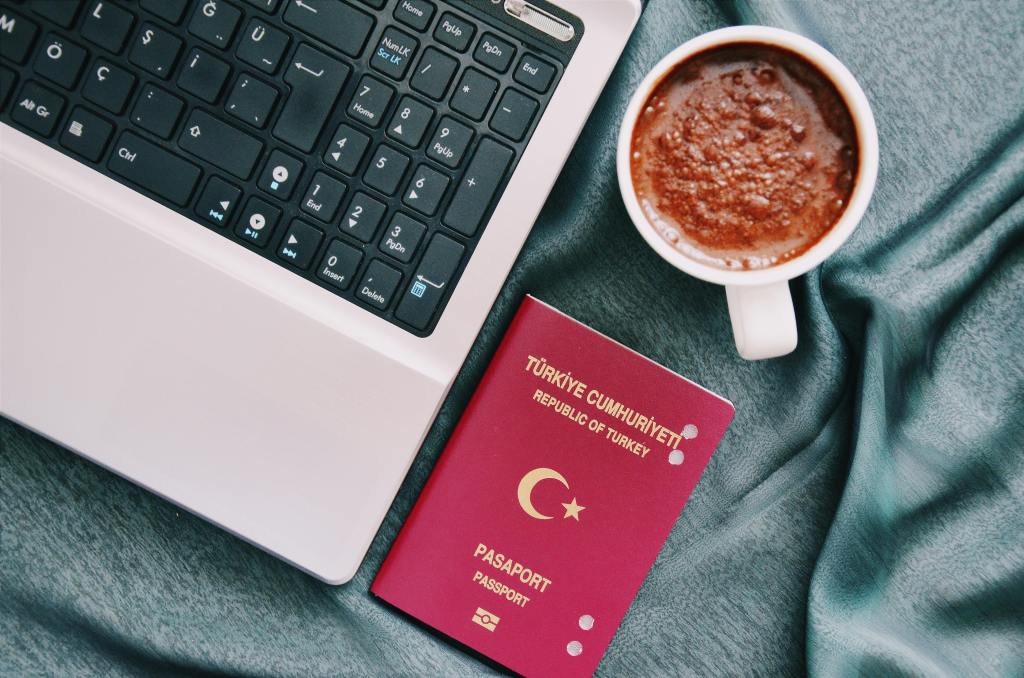 a turkish passport, coffe and a laptop