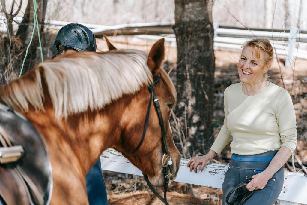 Female horse trainer smiling at a horse