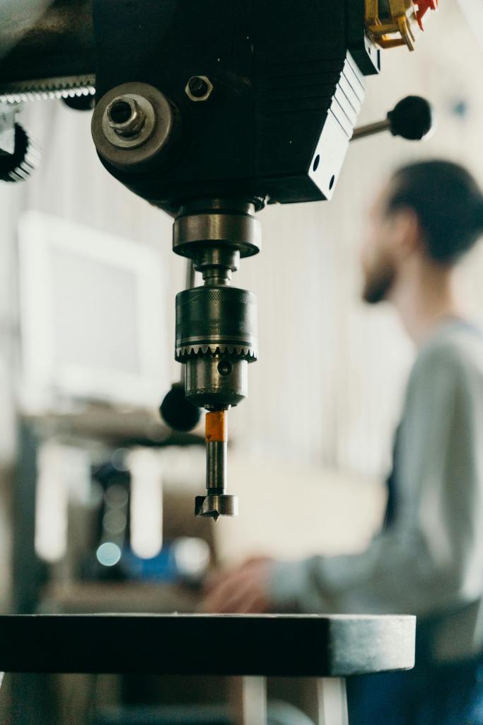 Close-up of a metal machine and a worker blurred in the background