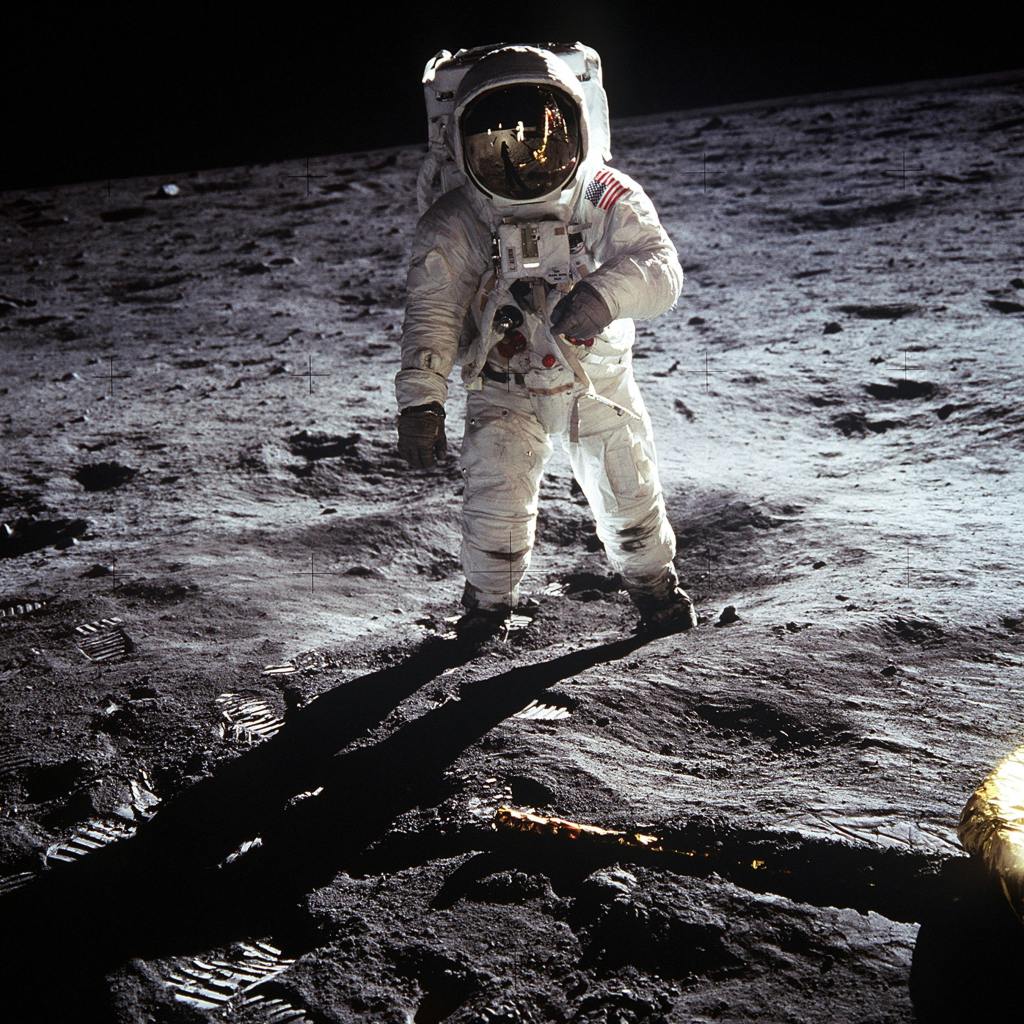 Astronaut walking on what appears to be the moon