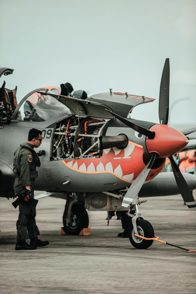 Soldier checking vintage airplane engine