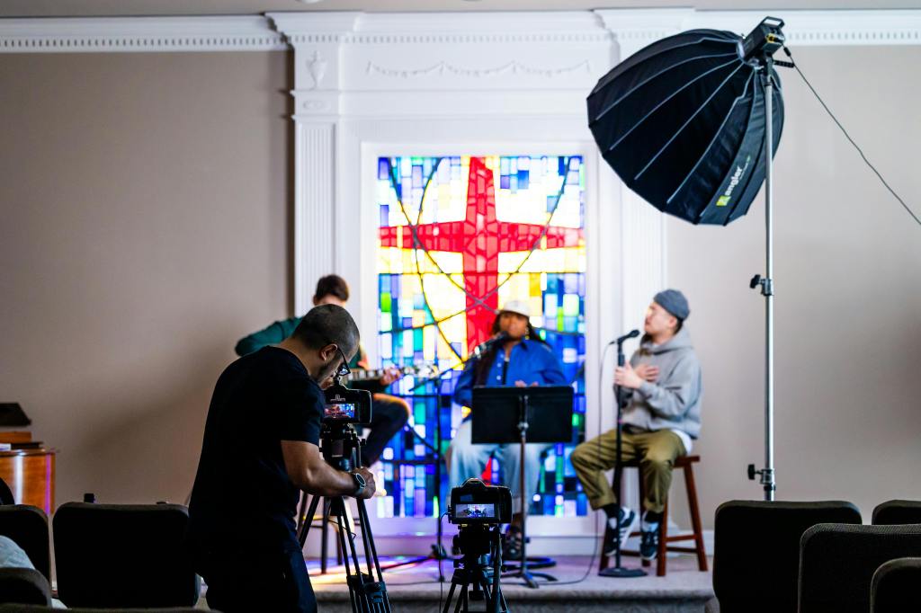 Cameraman taking a shot on set of a musical performance perhaps for the coverart of an album