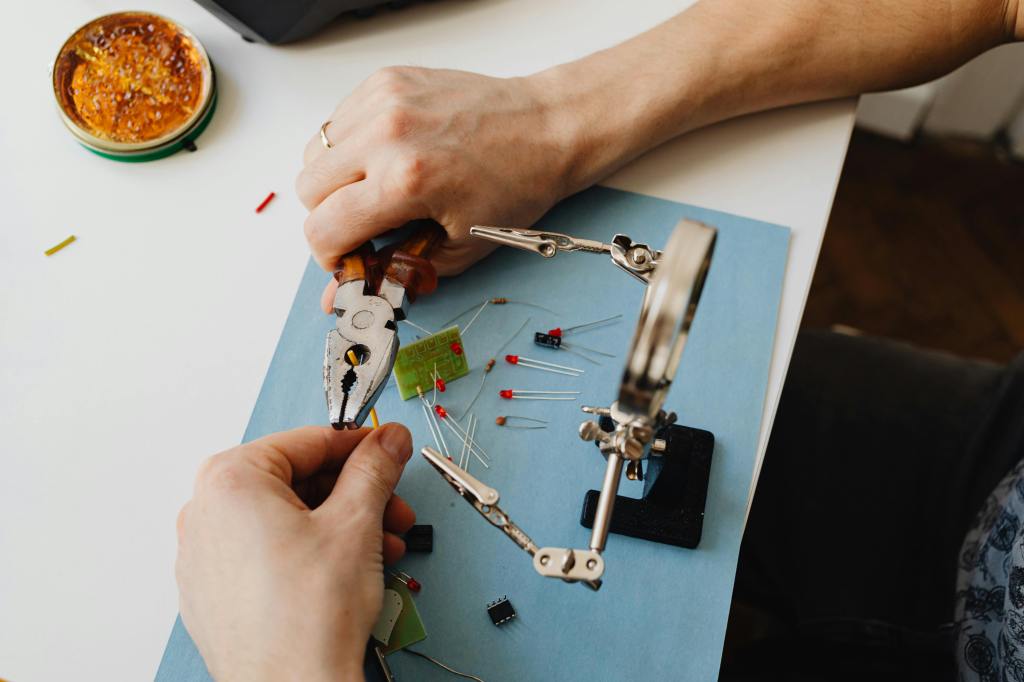 a close-up view of a person's hands assembling electronic components, seemingly from a small engine