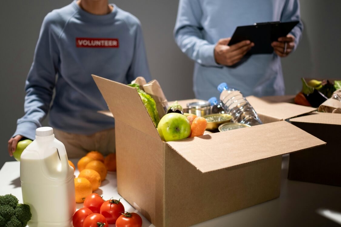 Volunteers filling boxes with daily goods.